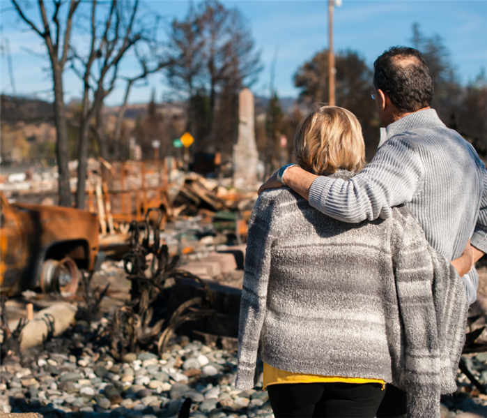 couple looking at disaster from tornado behind them