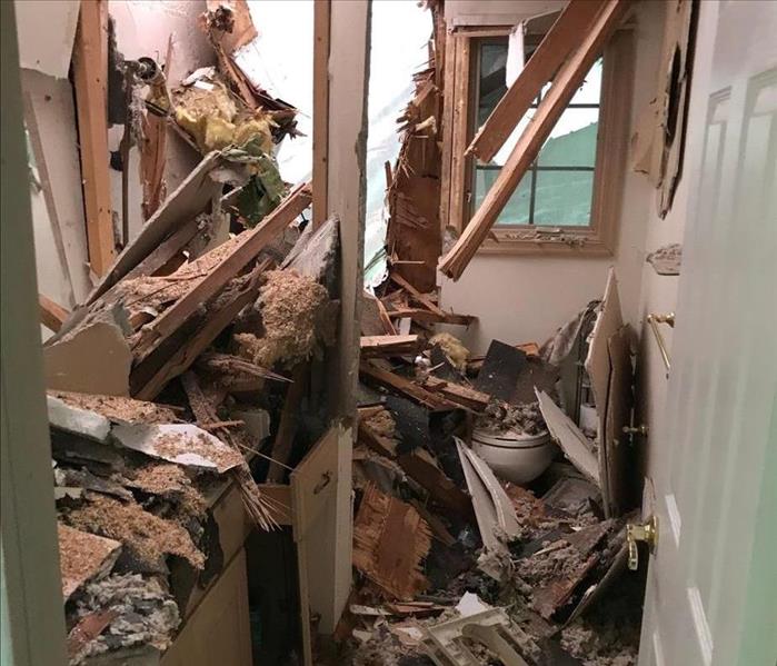 a 80 foot tree fell on this house causing storm damage to the entire second floor