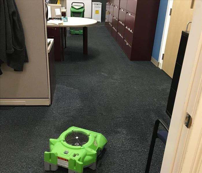 drying equipment in a flooded office with a wet carpet